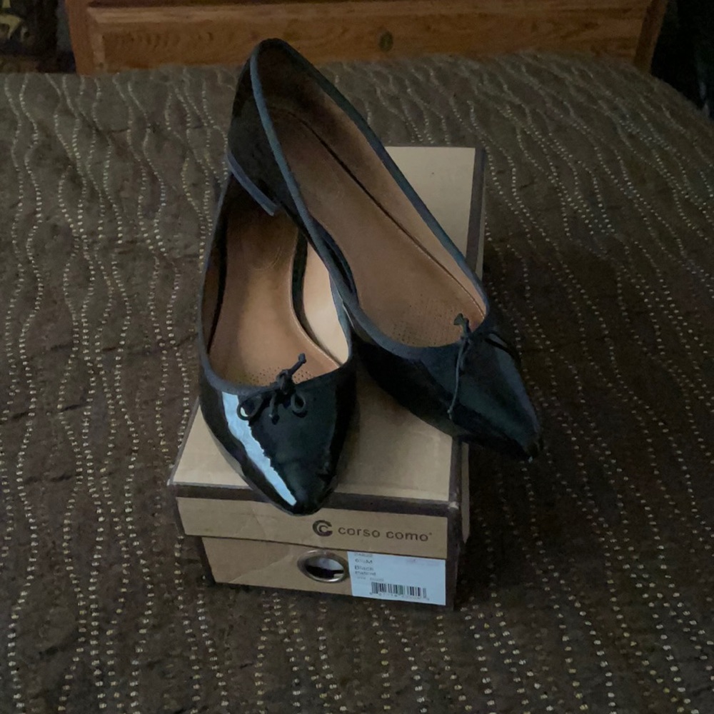 Corso Coma black patent leather ballerina flats.